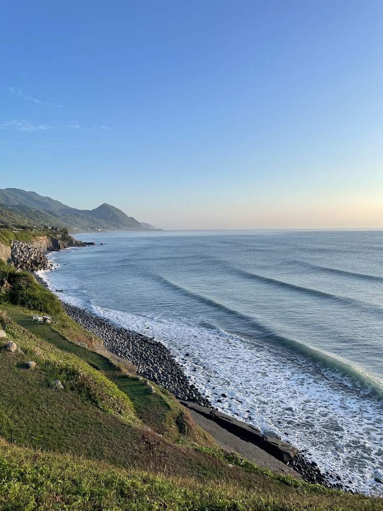 草地前方的海岸線與山海景觀