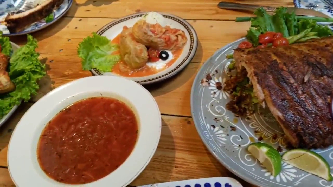 多道菜餚包含紅湯捲菜與烤排骨的餐桌