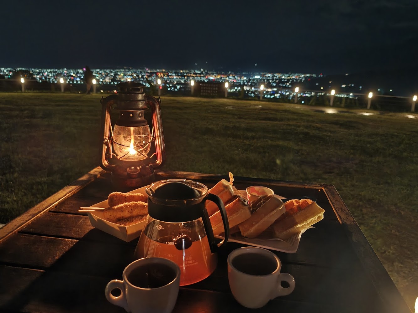 星星部落景觀咖啡桌上飲料茶壺三明治與夜景