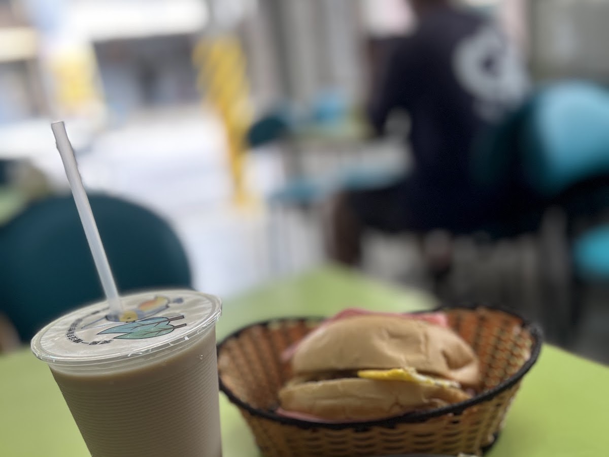 梓官美而美早餐店桌上擺著鮮奶茶、蛋餅與漢堡的豐盛早餐組合
