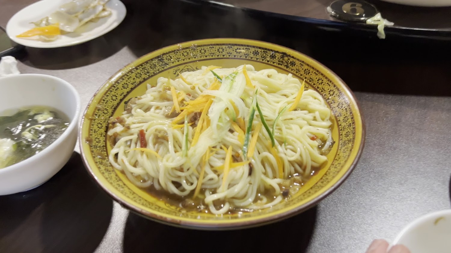 依嬤的店熱湯麵，旁邊有紫菜蛋花湯與一盤餃子