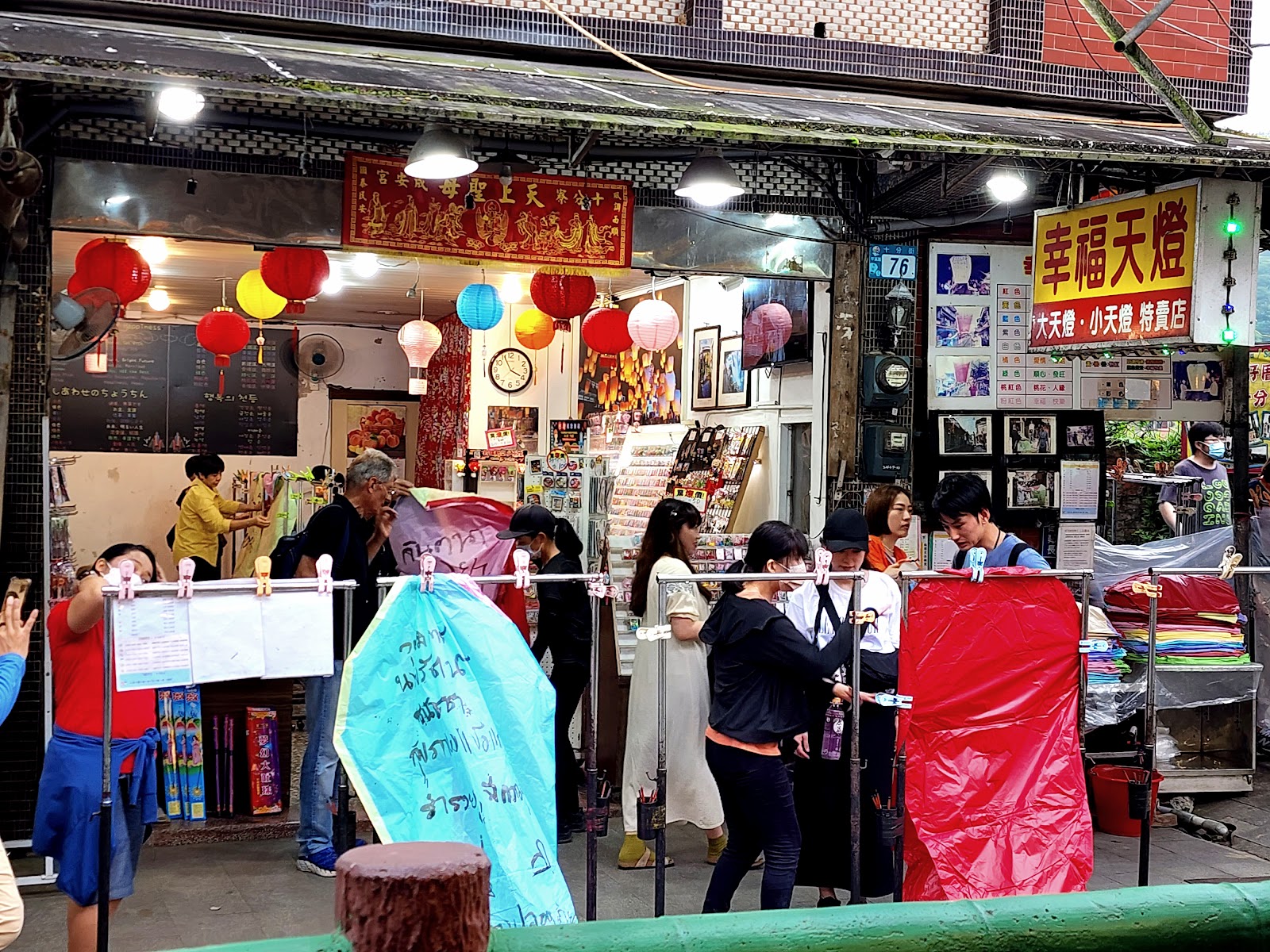 遊客在幸福天燈店前準備彩色天燈，現場氣氛熱鬧