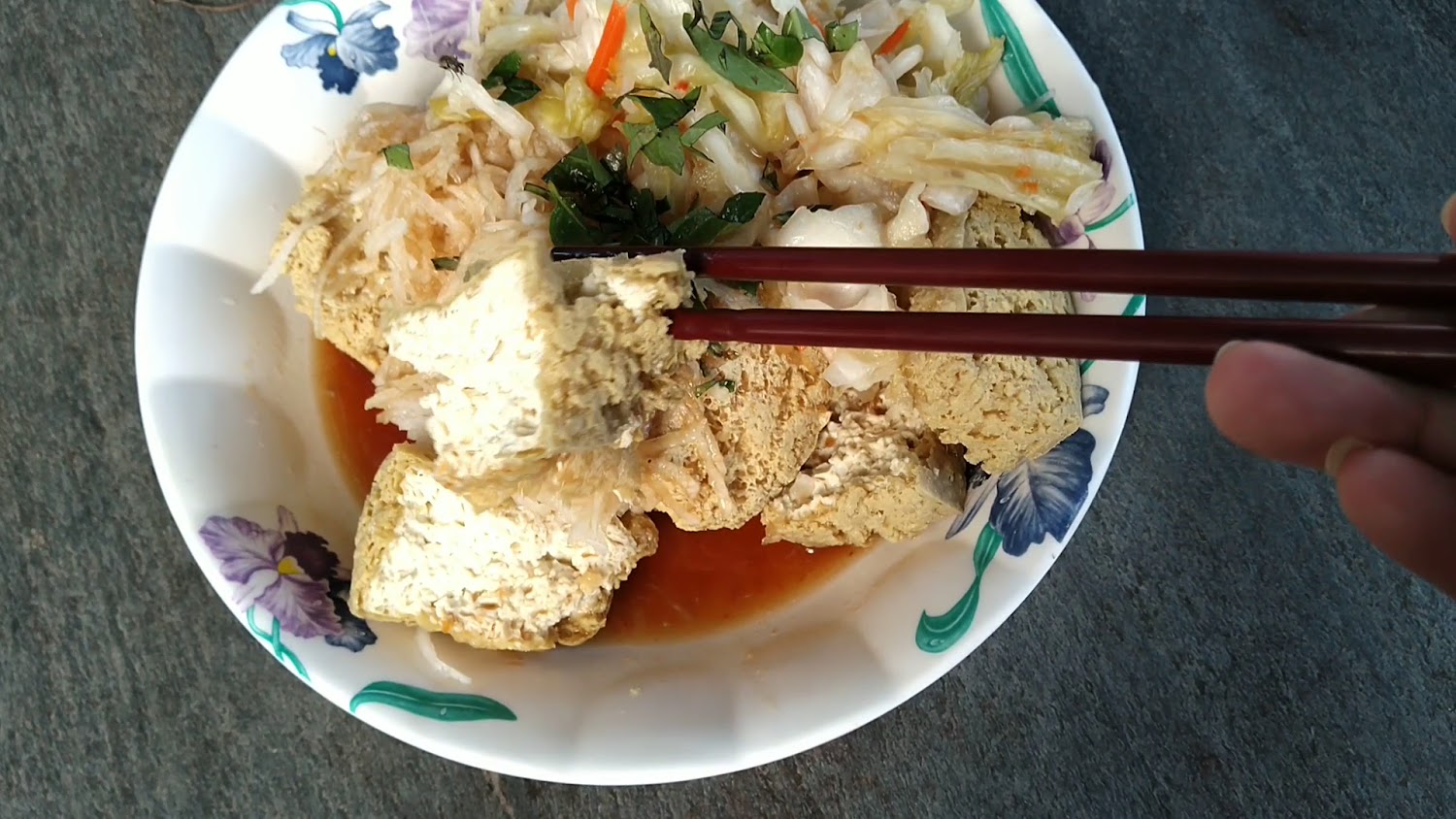金黃色臭豆腐搭配泡菜，筷子夾起一塊豆腐