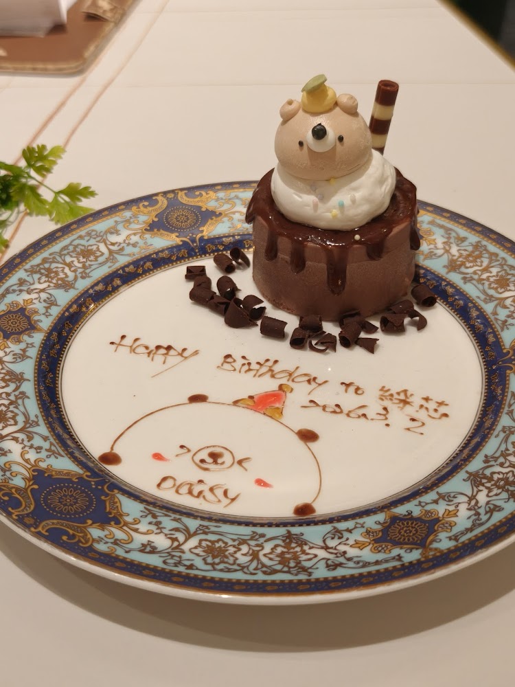 可愛熊造型慕斯蛋糕放在精美瓷盤上還有手寫生日祝福