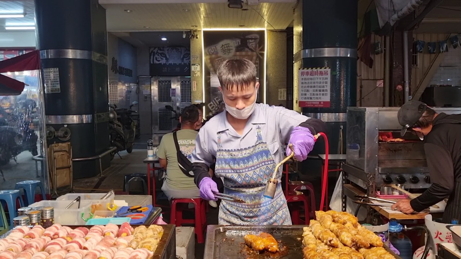 六合夜市攤販師傅用噴槍炙燒料理，視覺與嗅覺的雙重享受