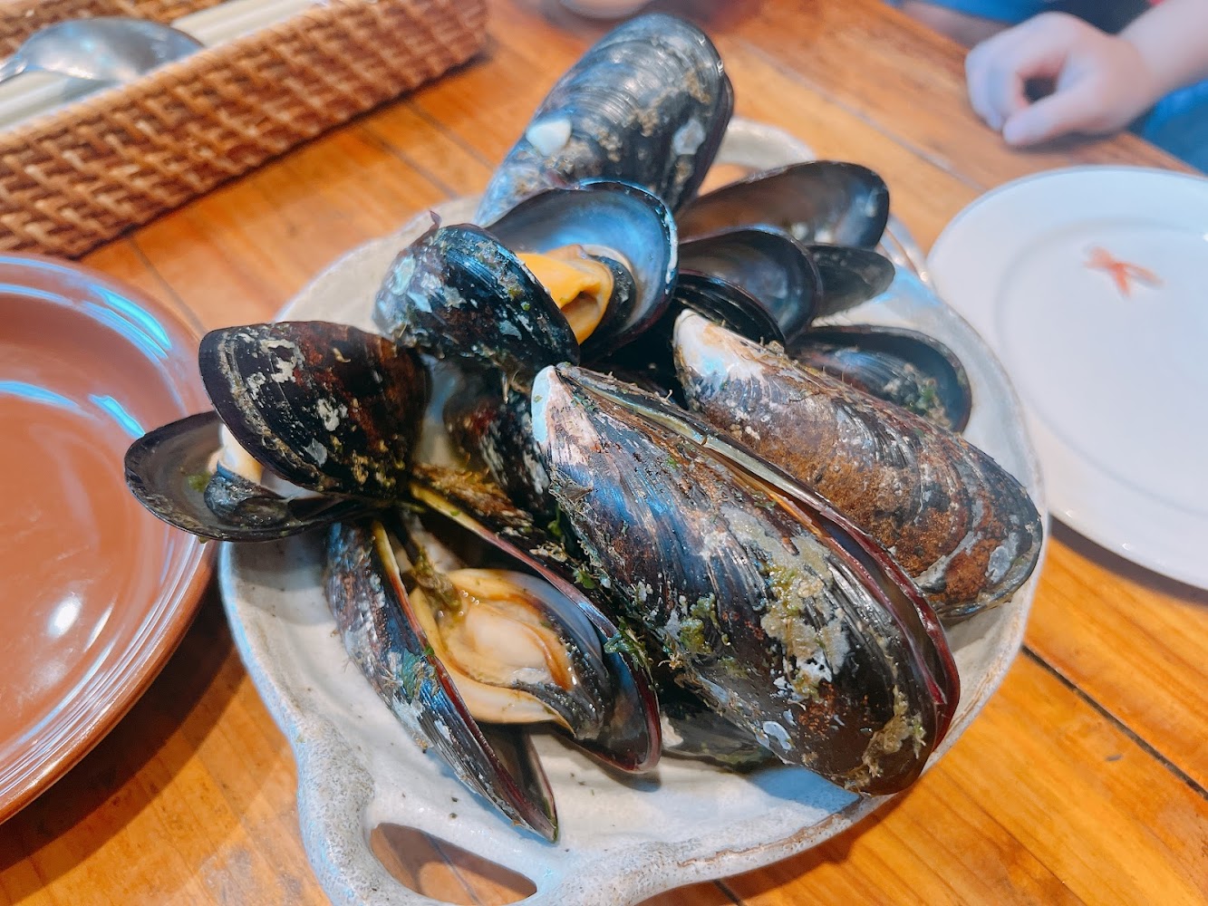 白色陶碗裝著新鮮淡菜擺放在木桌上