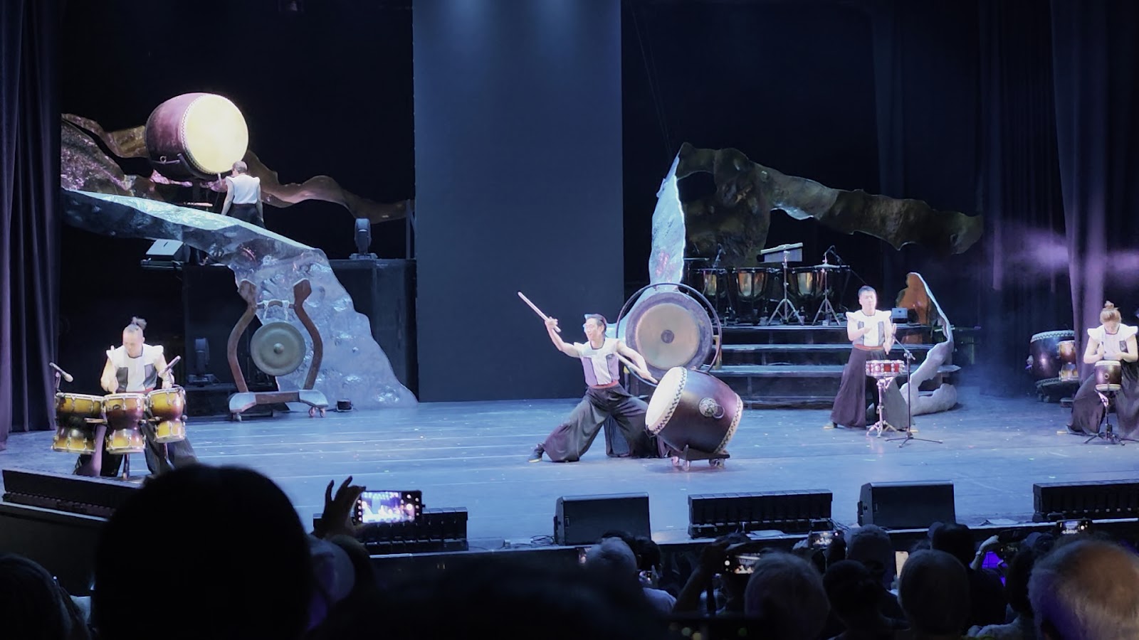 十鼓仁糖文創園區太鼓表演,多位鼓手站在巨石佈景前擊打太鼓,觀眾在台下觀賞