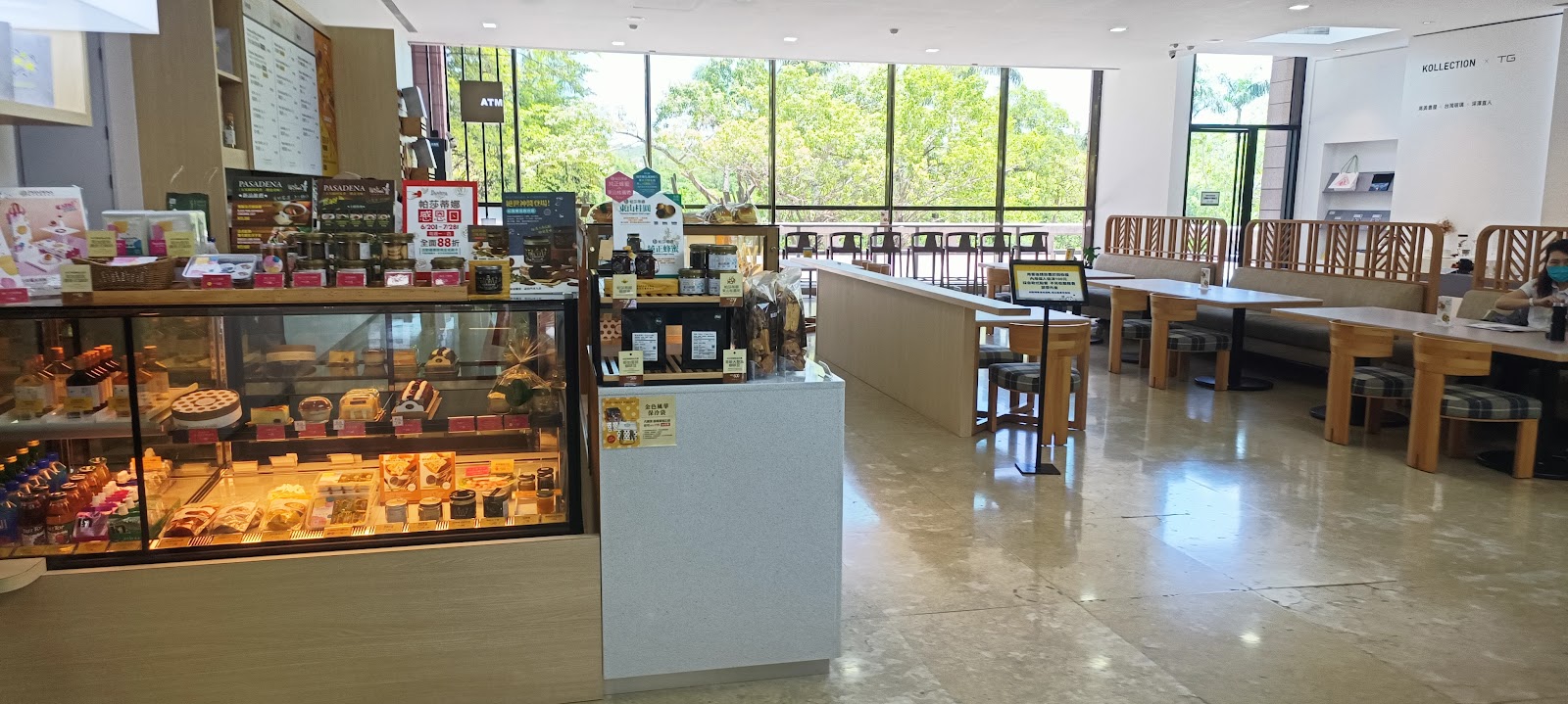 高雄市立美術館館內咖啡廳甜點蛋糕展示櫃，落地玻璃窗外綠樹