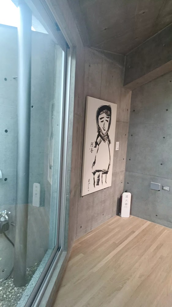 室內水泥牆與水墨風人物畫作