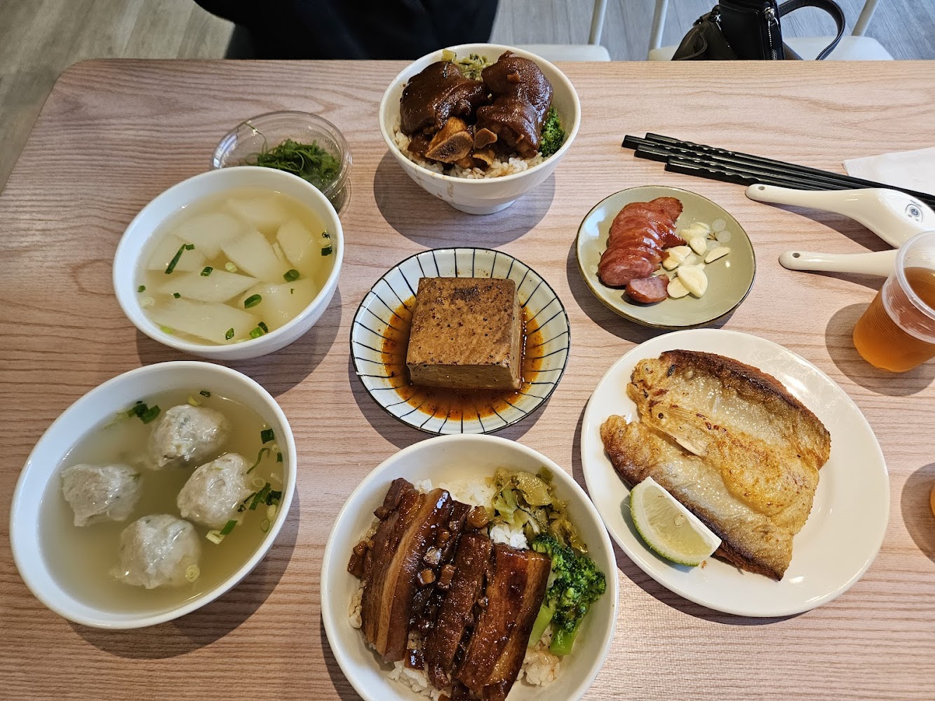 豐盛台式餐桌，有滷肉飯、豬腳飯、炸魚、香腸、滷豆腐、湯品與飲料。