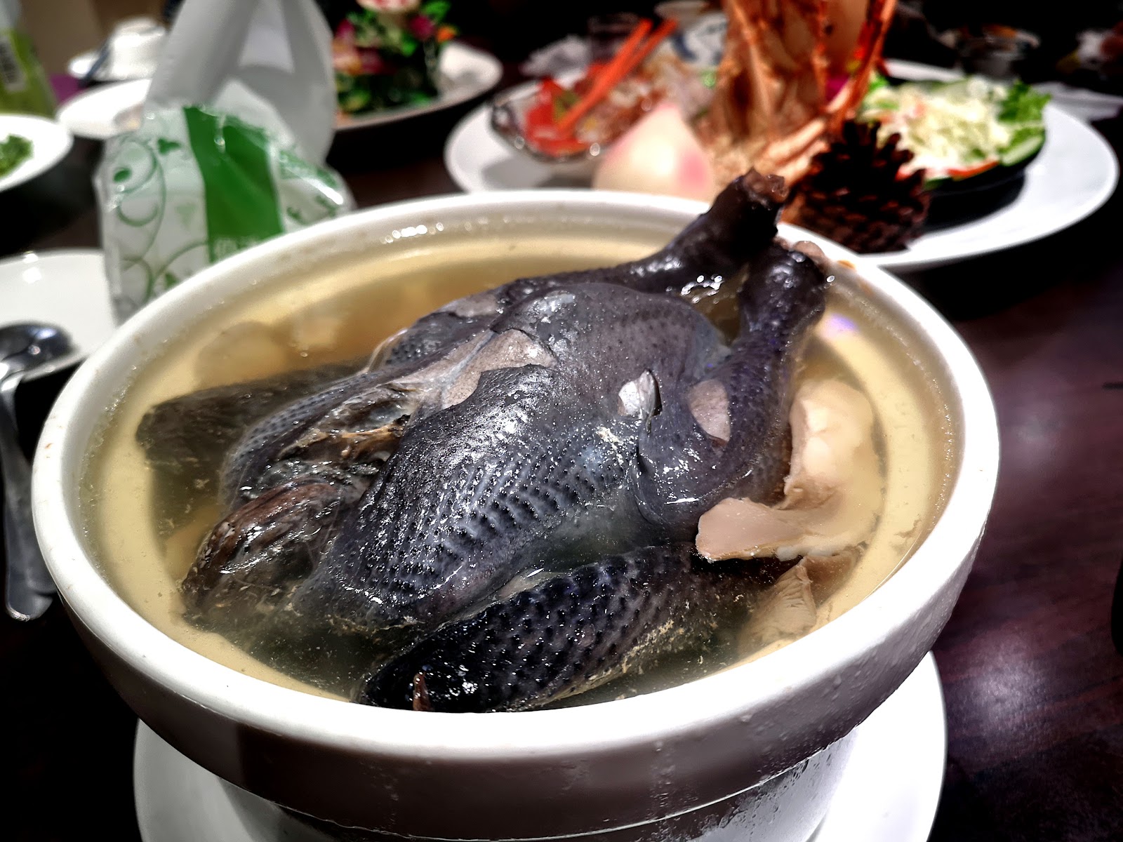 悅禾小館砂鍋烏骨雞全雞湯，整隻烏骨雞浸於清澈湯頭