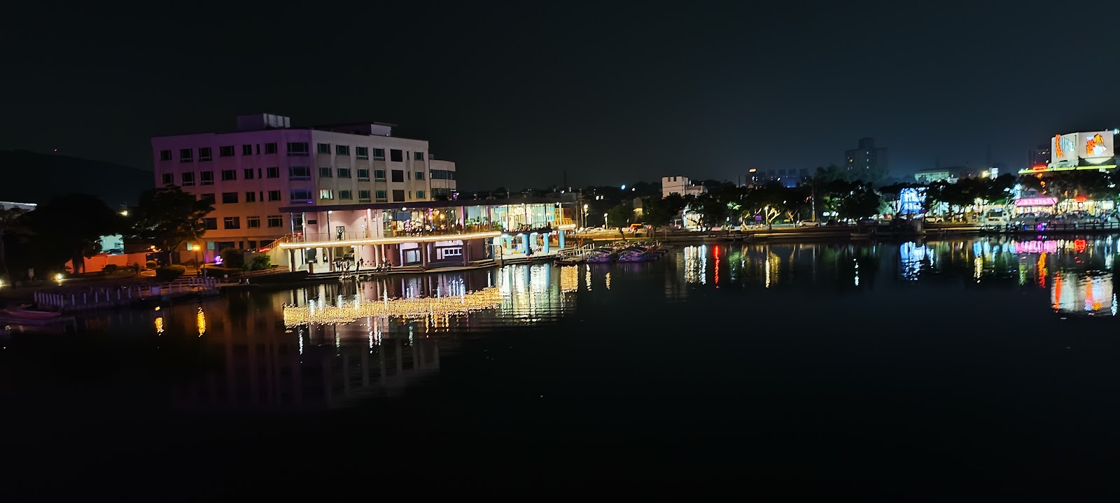 龍潭大池夜景，霓虹燈光璀璨，建築彩燈倒映水中，浪漫迷人