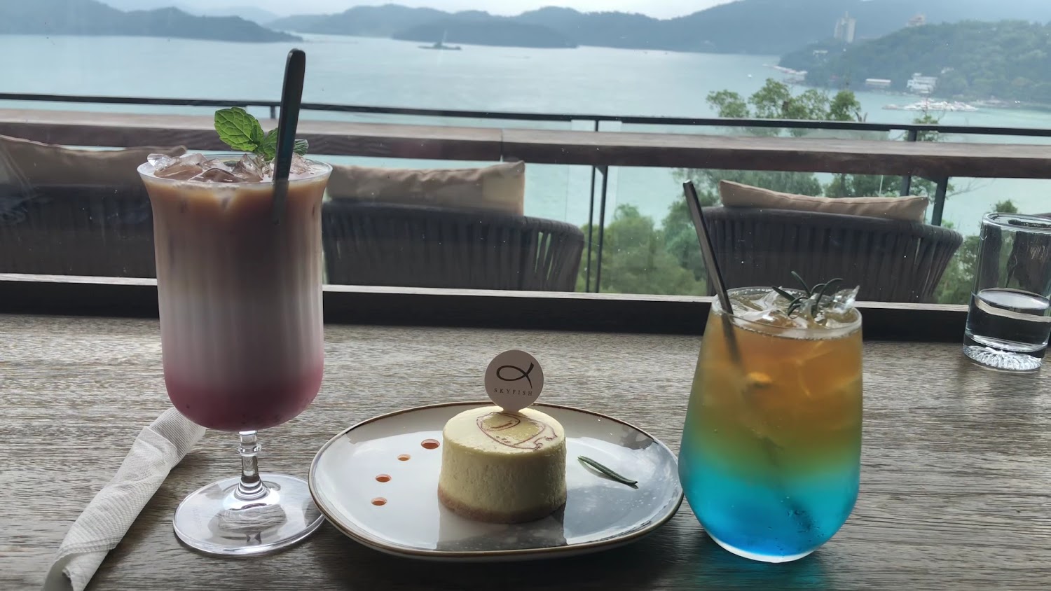 漸層飲料彩色氣泡飲與精緻蛋糕配湖岸山景
