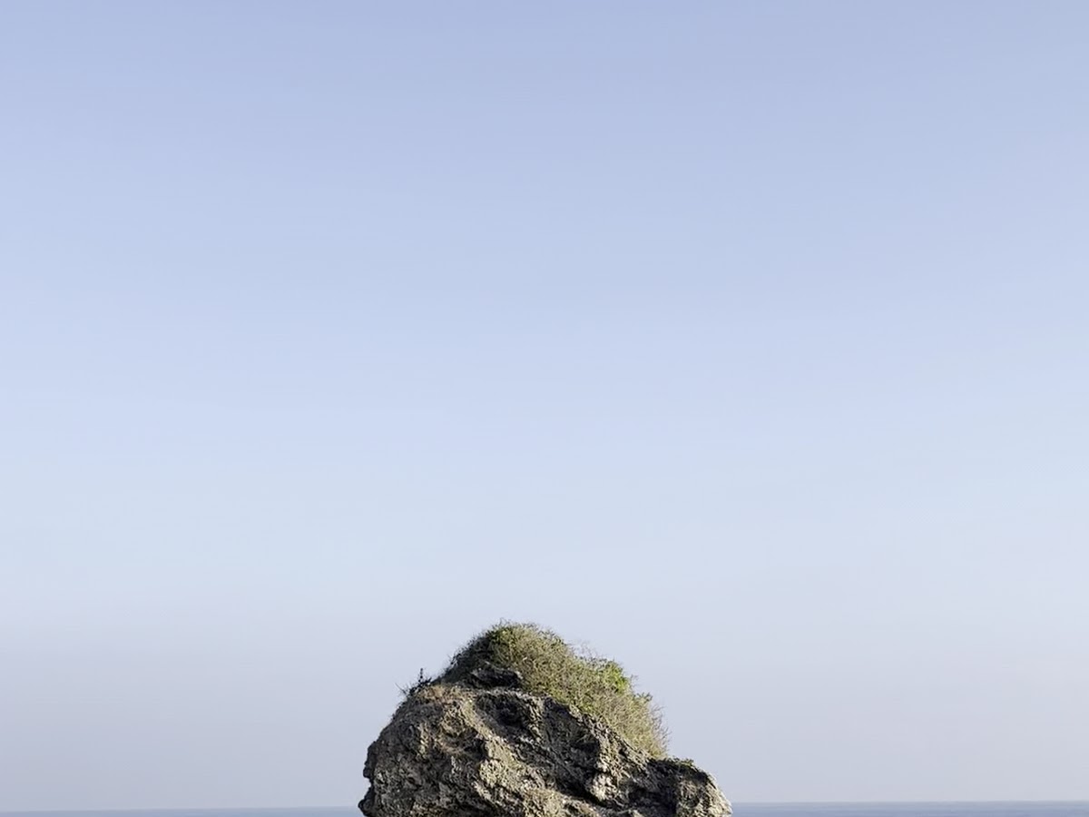 從沙灘遠望花瓶石全景，晴天藍天