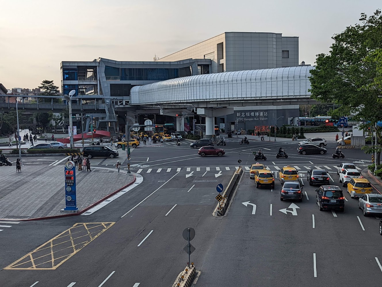新北板橋轉運站外觀，前方是馬路和多輛汽車、計程車，展現繁忙都市交通景象