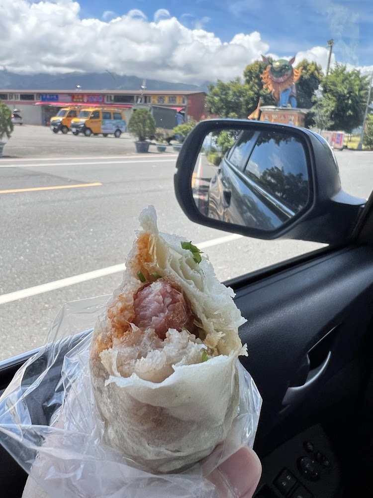 手拿包有香腸與花生粉配料的特色小吃
