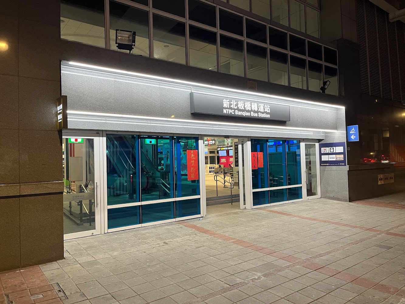 新北板橋轉運站入口，門口乾淨明亮，內部可見電扶梯與便利商店標誌