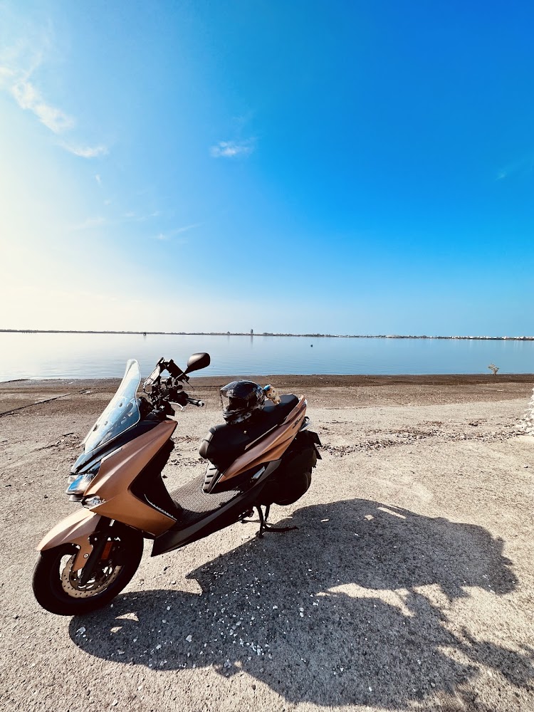 水邊停放機車與寧靜湖面藍天