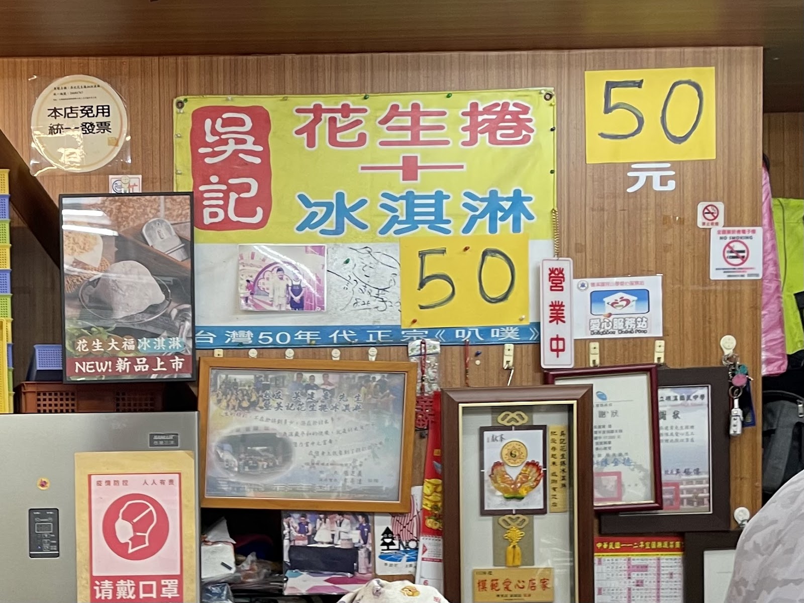 吳記花生捲冰淇淋招牌，黃底紅字寫著花生捲冰淇淋50元
