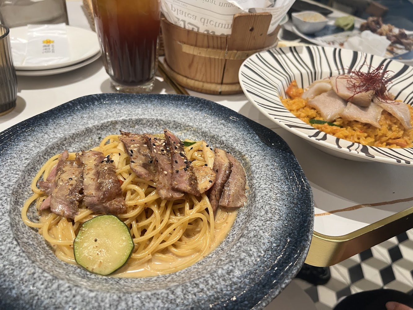 桌上有牛肉義大利麵豬肉燉飯與飲料