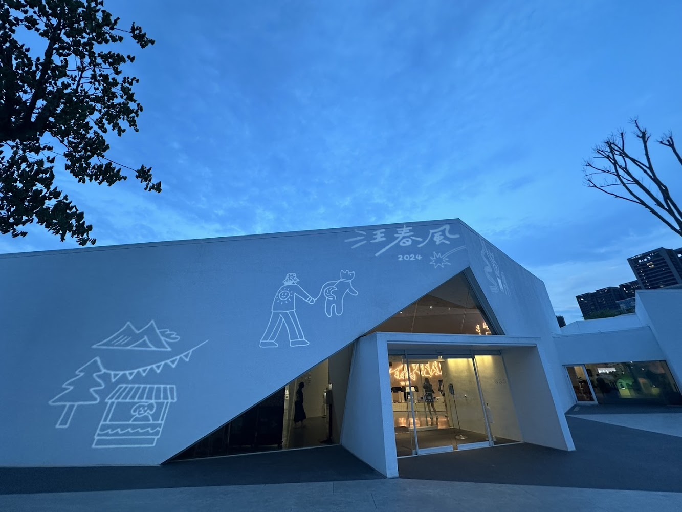 白色建築外牆與汪春風2024字樣