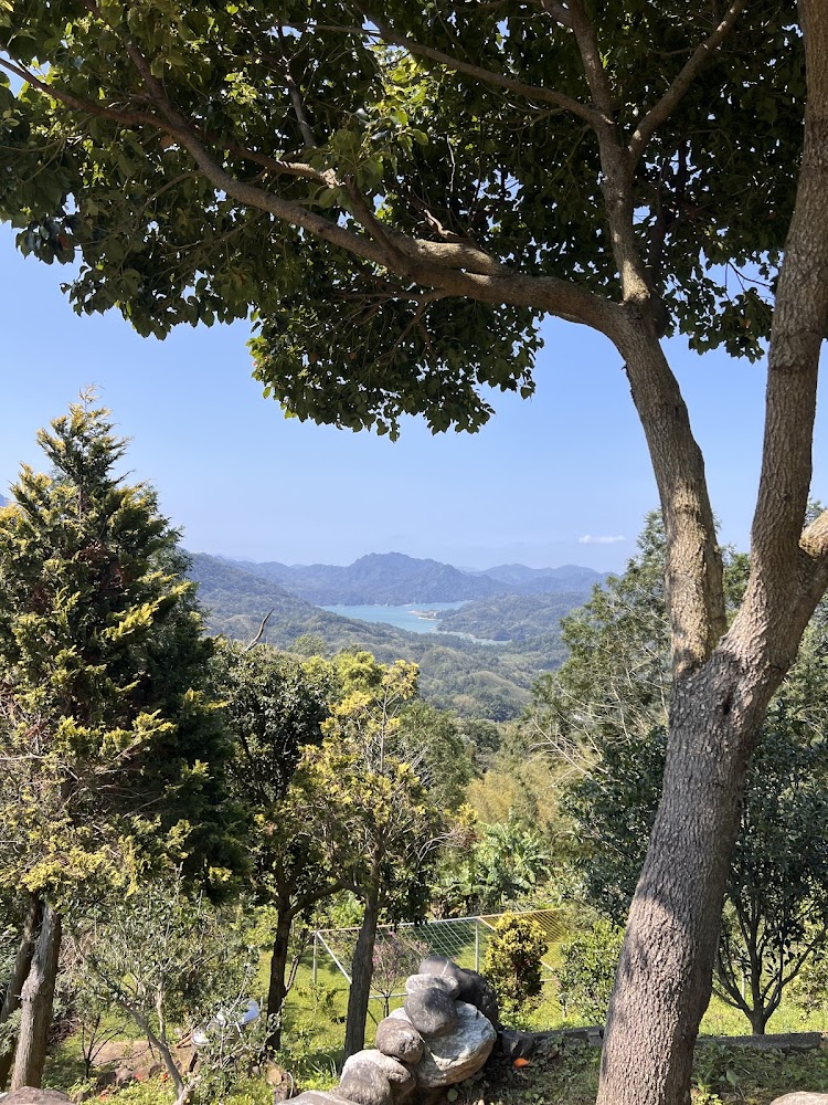 綠意山林與藍色湖泊及遠方山脈晴朗天空