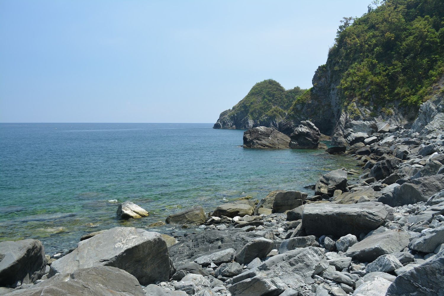 愛情鎖海灘礁石與山坡海岸線