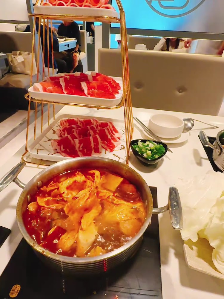 紅湯火鍋與多層肉盤聚餐畫面