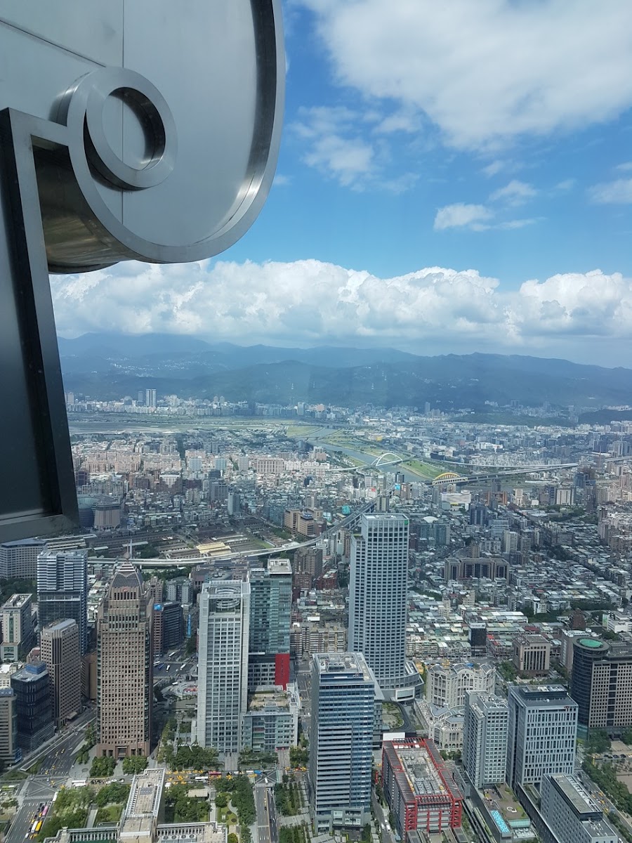 台北101觀景台俯瞰台北盆地全景，遠山藍天，台北一日遊