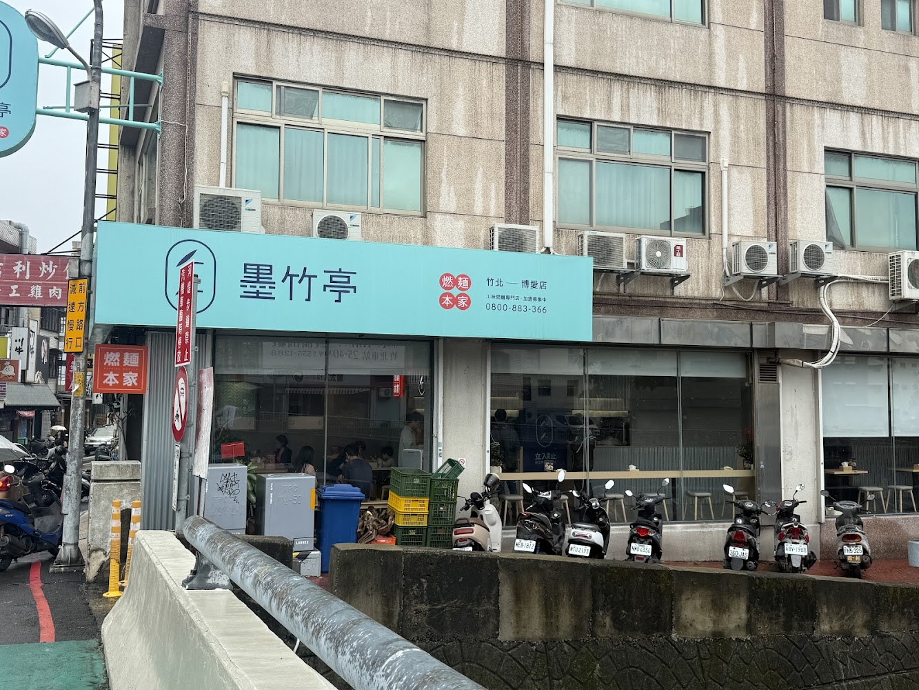 墨竹亭燃麵本家竹北博愛店外觀，位於博愛街老式大樓一樓，門口可停放機車。