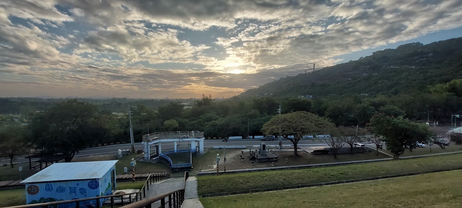 夕陽天空下山坡樹林與步道設施的開闊景觀