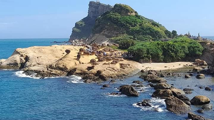 奇特海岸岩石礁石碧藍大海與綠丘