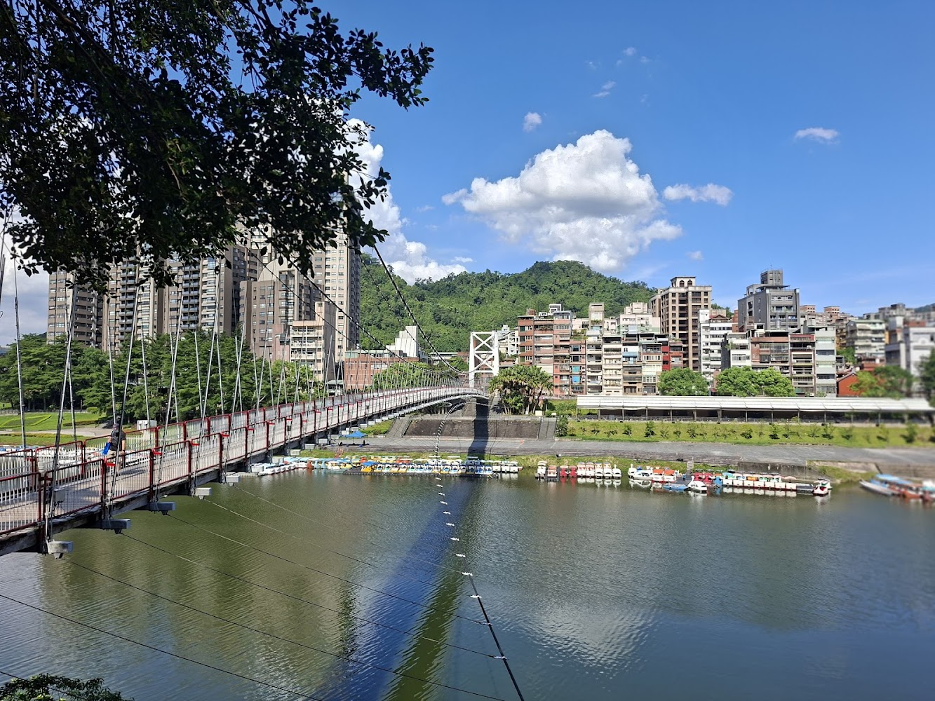 藍天白雲下的碧潭吊橋與腳踏船