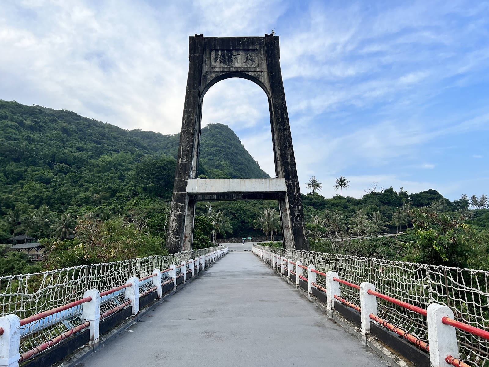 舊東河橋拱形橋塔正面，白橋面紅白欄杆，台東東河著名地標