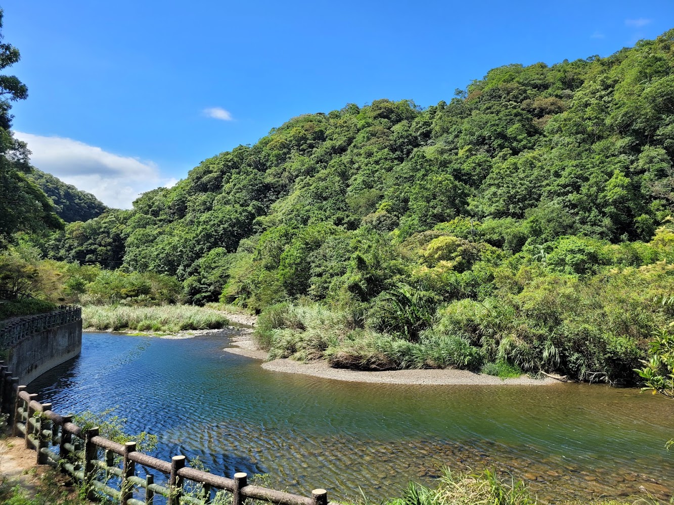 河流、青翠樹林與藍天構成的三水潭自然景色