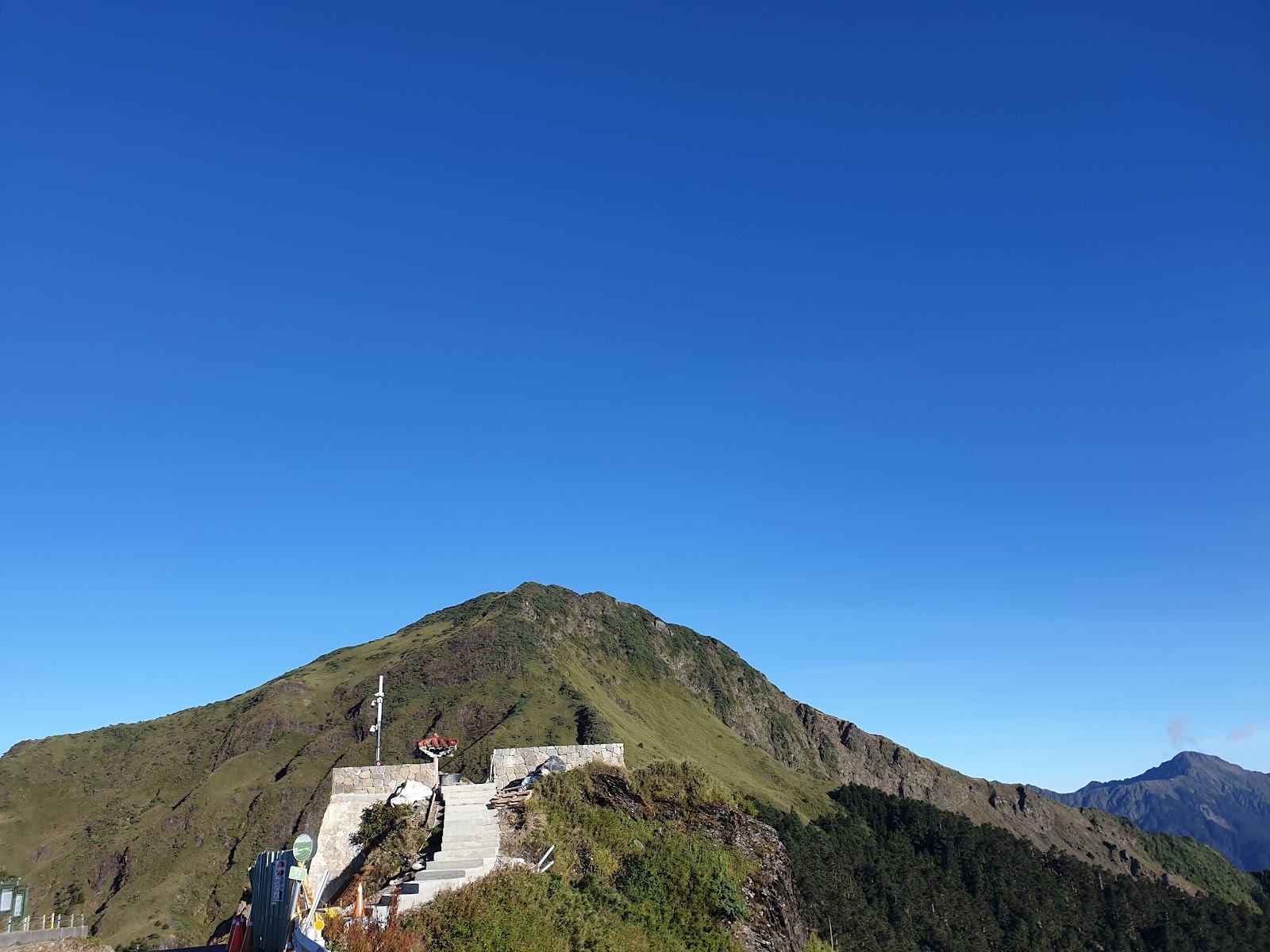 合歡山觀景石板步道通往山頂，深藍晴空萬里，右方高聳山脊清晰