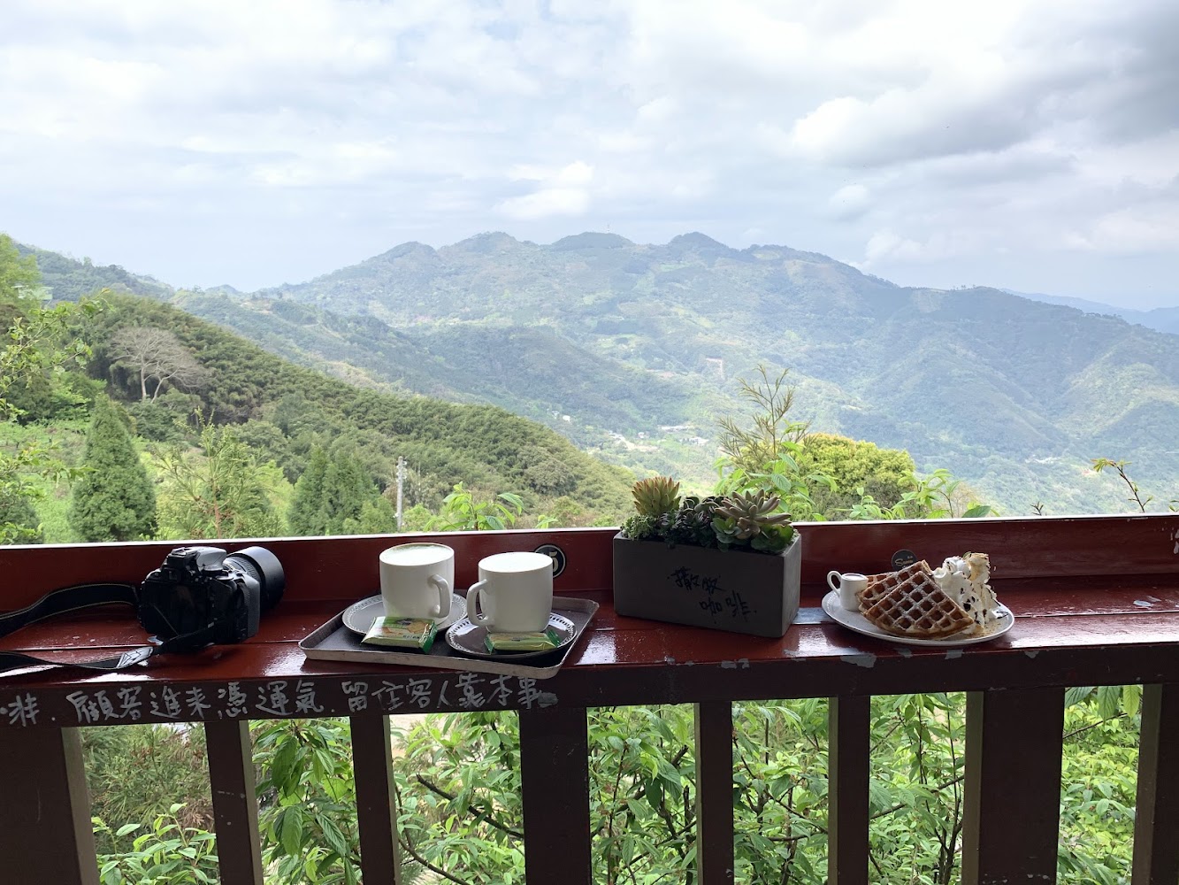 陽台上放著飲料點心相機與多肉植物的山景桌面