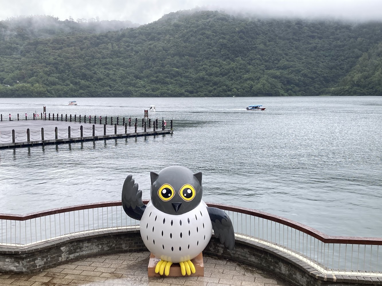 大型貓頭鷹雕像與湖景碼頭