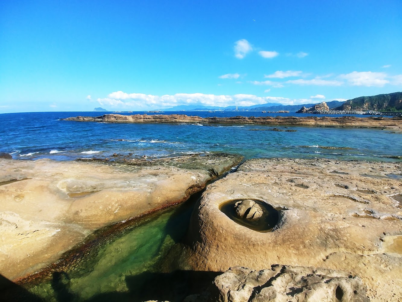 野柳海岸坑洞岩石與遠方山海景