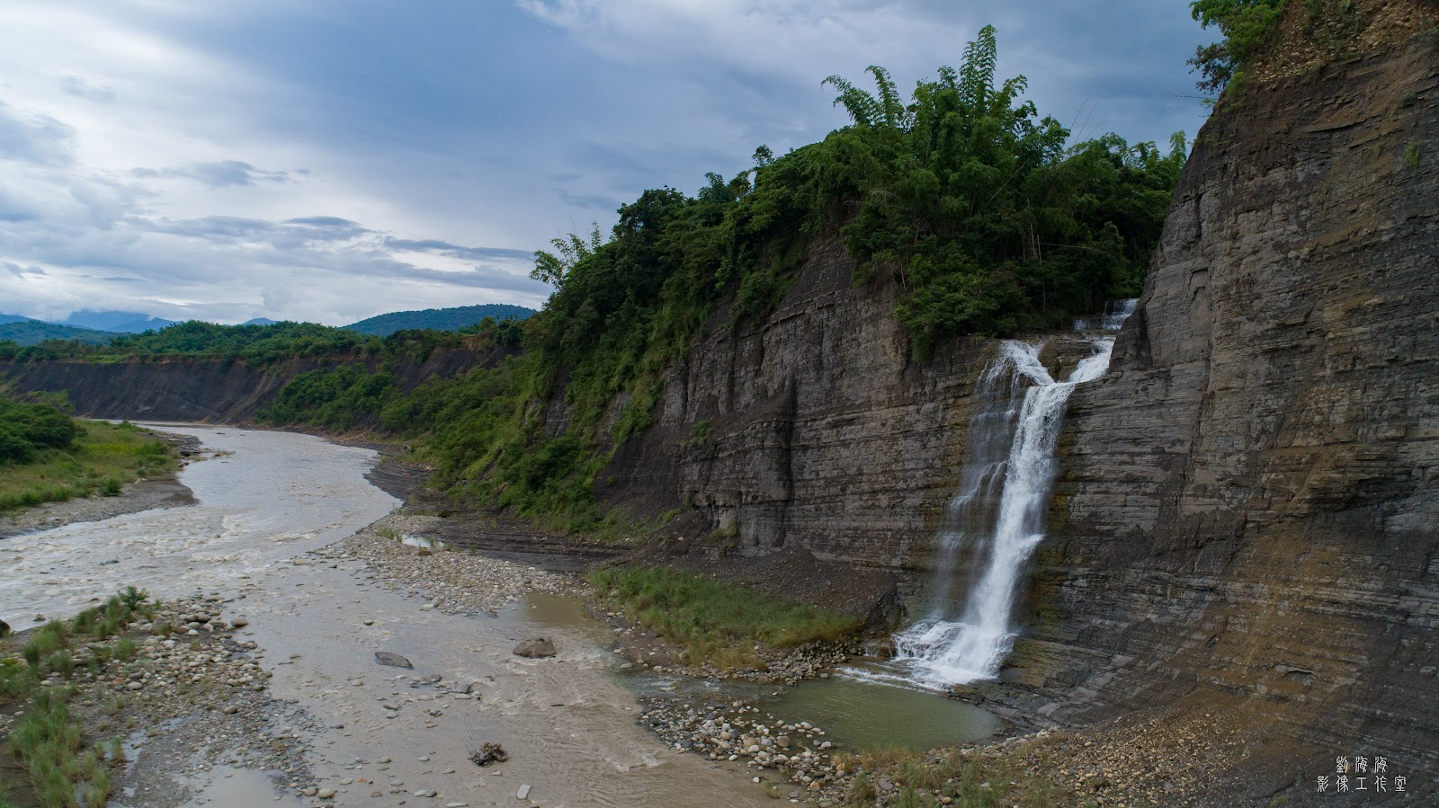 高雄杉林白水泉瀑布全景，瀑布從灰色岩壁傾瀉而下，左側寬廣溪床