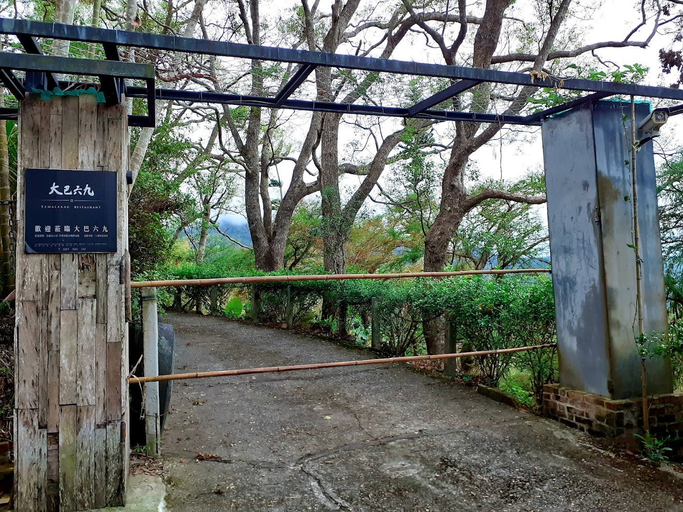大巴六九景觀餐廳入口木製招牌與綠意庭院