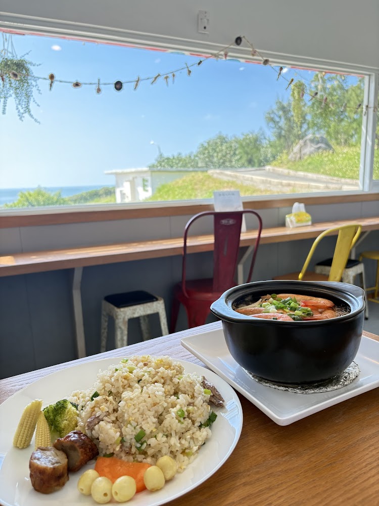 炒飯和海鮮湯放在木餐桌與大窗景前