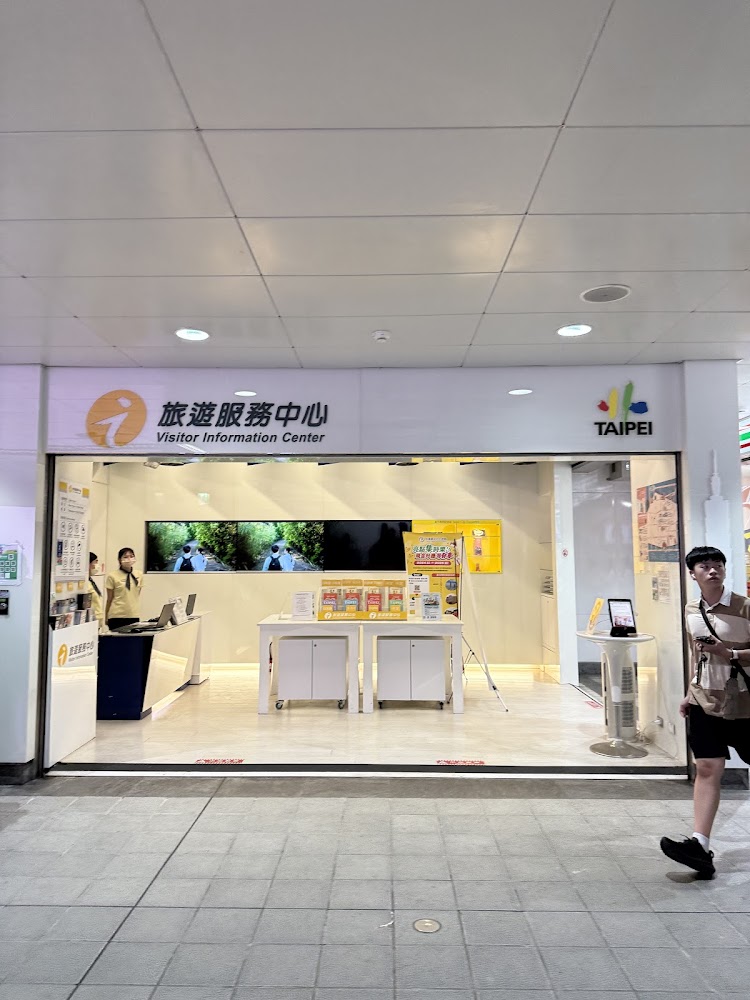 捷運台北101世貿站旅遊服務中心，櫃台明亮且有工作人員提供諮詢。