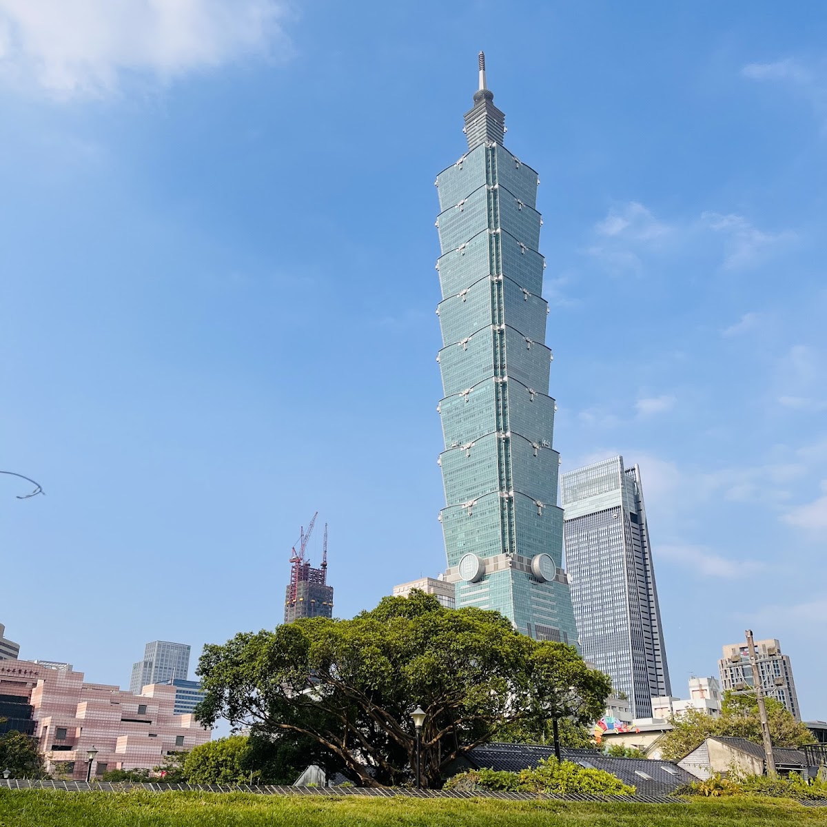四四南村草坪仰望台北101信義區一日遊景點，眷村老房子與摩天大樓對比