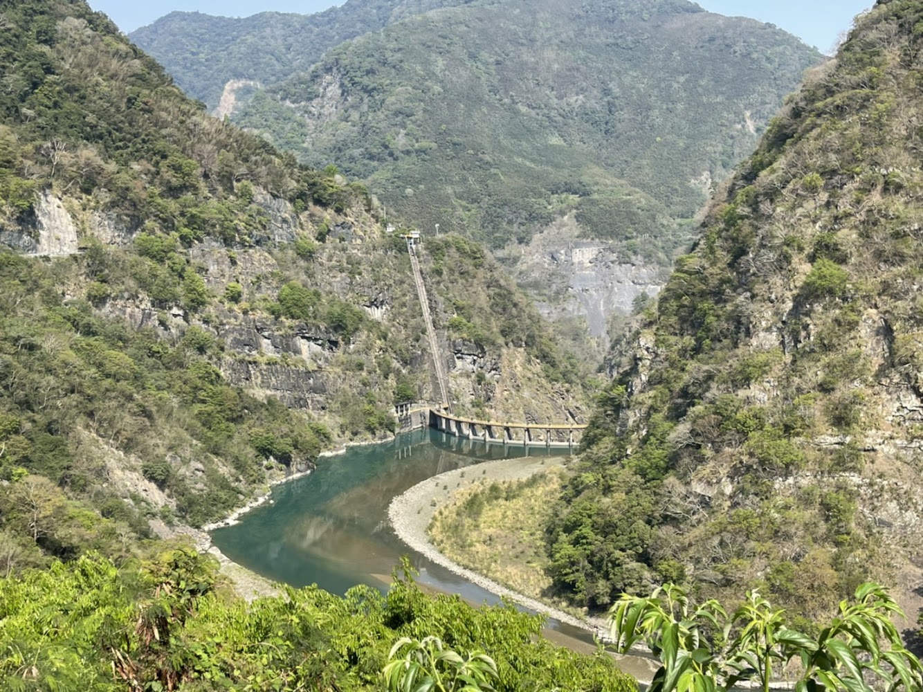 群山環繞的溪谷與蜿蜒河流及壩體設施