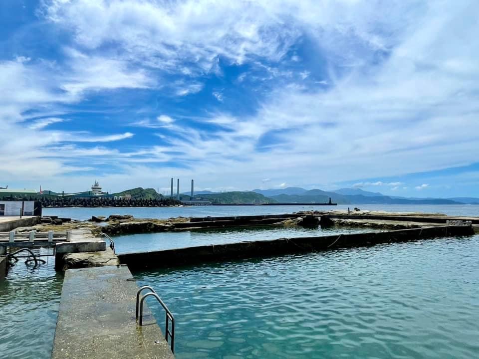 靠海的天然泳池與欄杆，前景石造池體，遠方可見海天一色