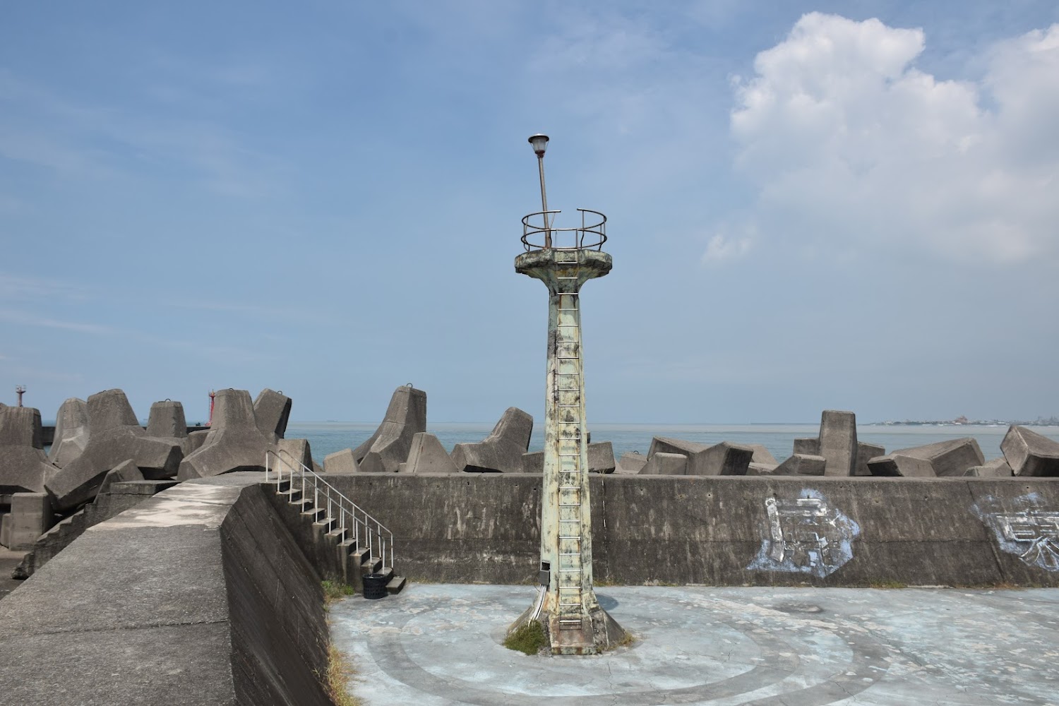 海邊防波堤與老舊燈塔及大量消波塊