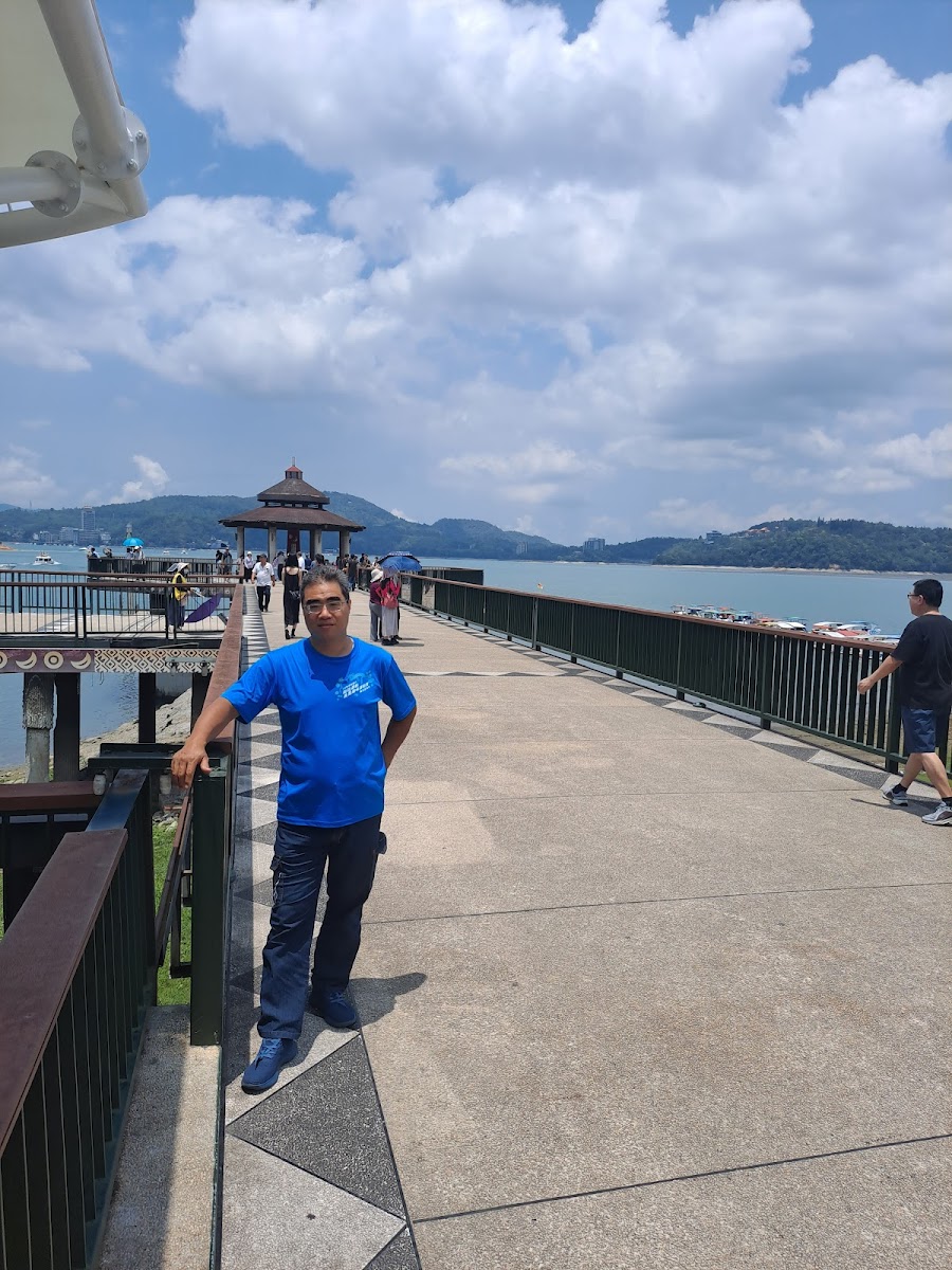 日月潭湖畔步道，中式涼亭倒映湖面，群山環繞