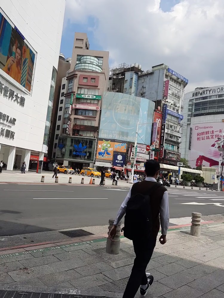 西門街頭高樓廣告與計程車景色