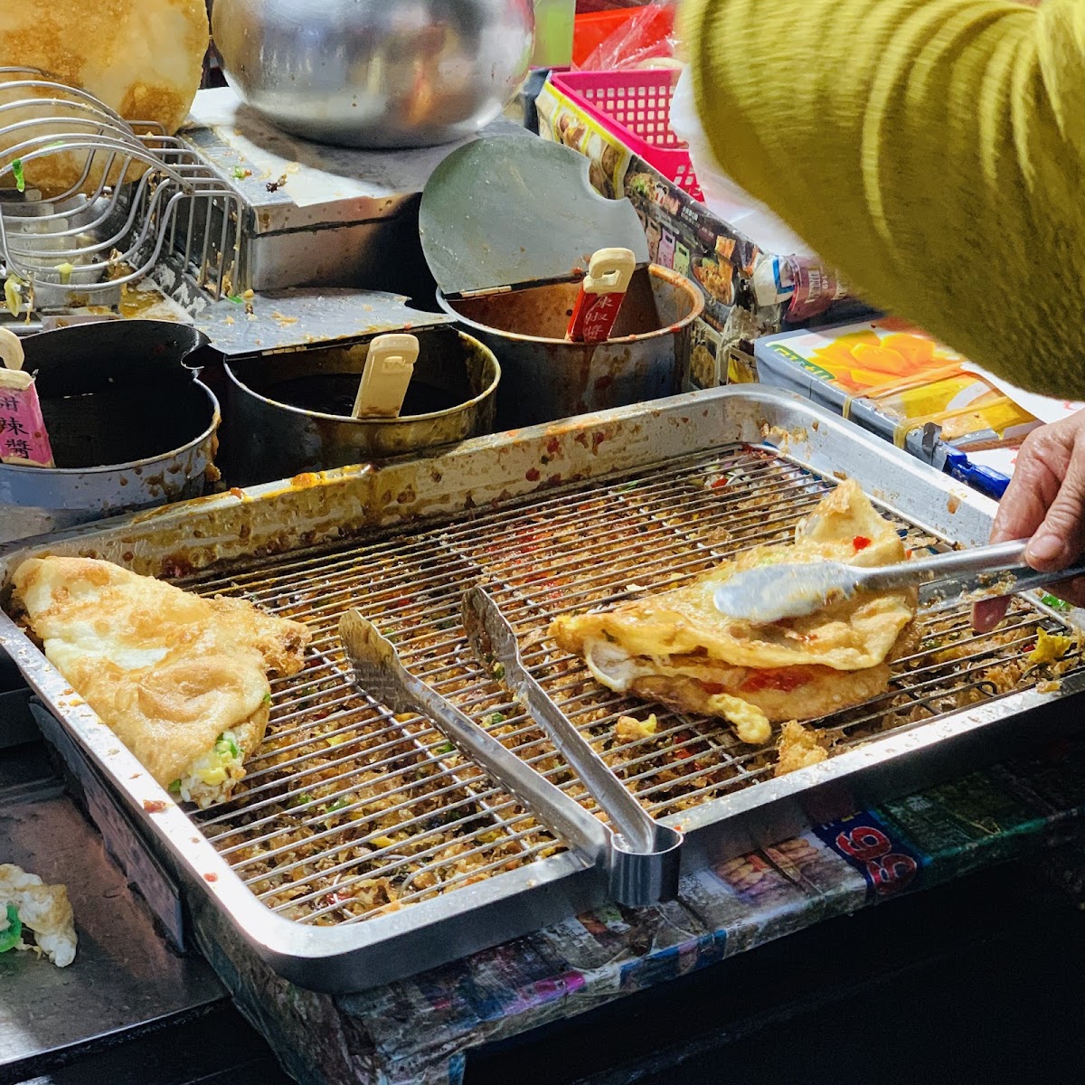 柯氏蔥油餅攤主夾起蔥油餅，金黃酥脆，攤位整體